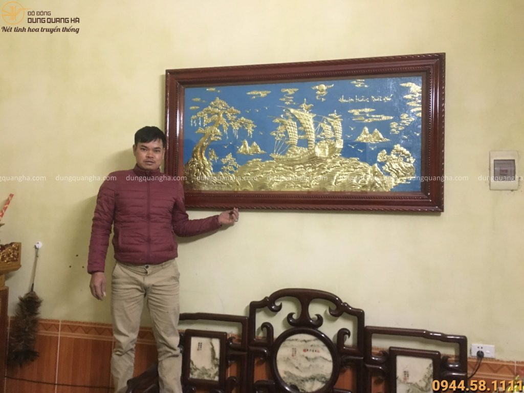 Nhân viên Dung Quang Hà treo và lắp đặt thành công bức tranh đồng